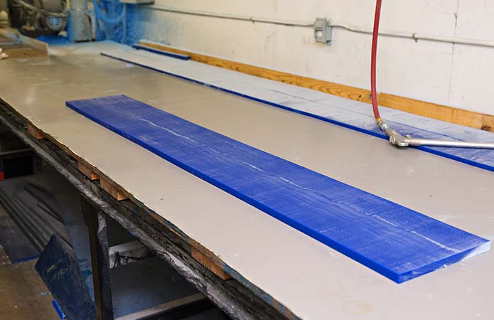 Blue polyurethane load bearing pad in a fabrication shop